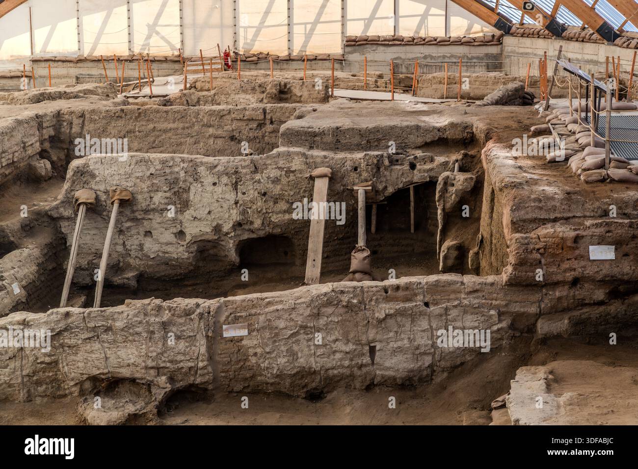 Supporti in legno sostengono i muri in mattoni di fango scavati di una casa di Çatalhöyük vicino a Küçükköy, in Turchia, dove sacchi di sabbia lungo il bordo della trincea trattengono il terreno circostante. A Çatalhöyük, uno degli insediamenti neolitici più famosi al mondo, le case erano costruite direttamente una contro l'altra senza strade, con l'ingresso attraverso un'apertura nel tetto. Foto Stock