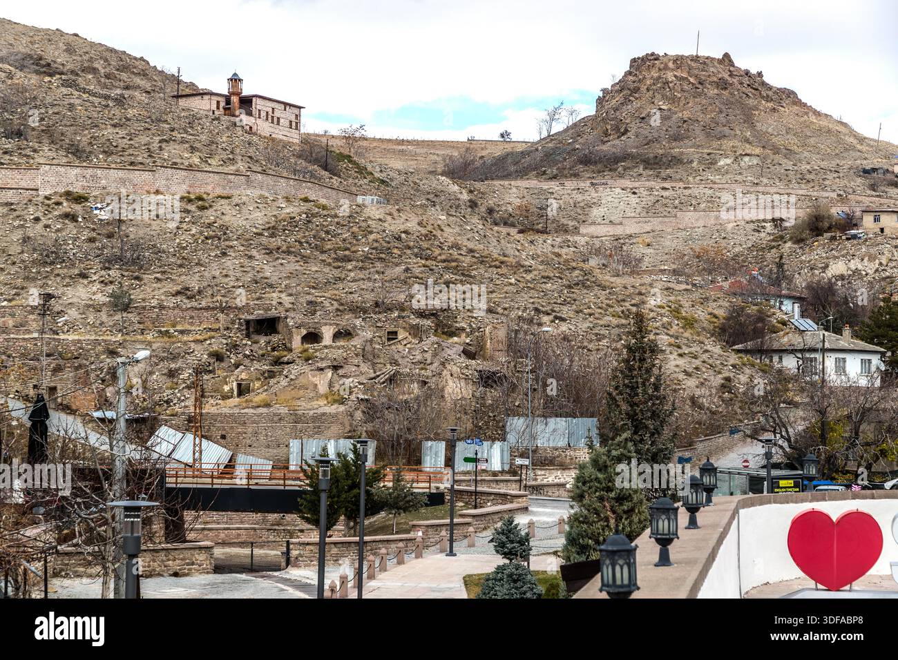 Vecchie case di pietra in parte rovinate e un minareto segnano la collina sopra Sille vicino a Konya, Turchia. Il villaggio, un tempo abitato principalmente da greci cappadoci, si trova nel distretto di Selçuklu ed è ora un insieme storico protetto. Foto Stock