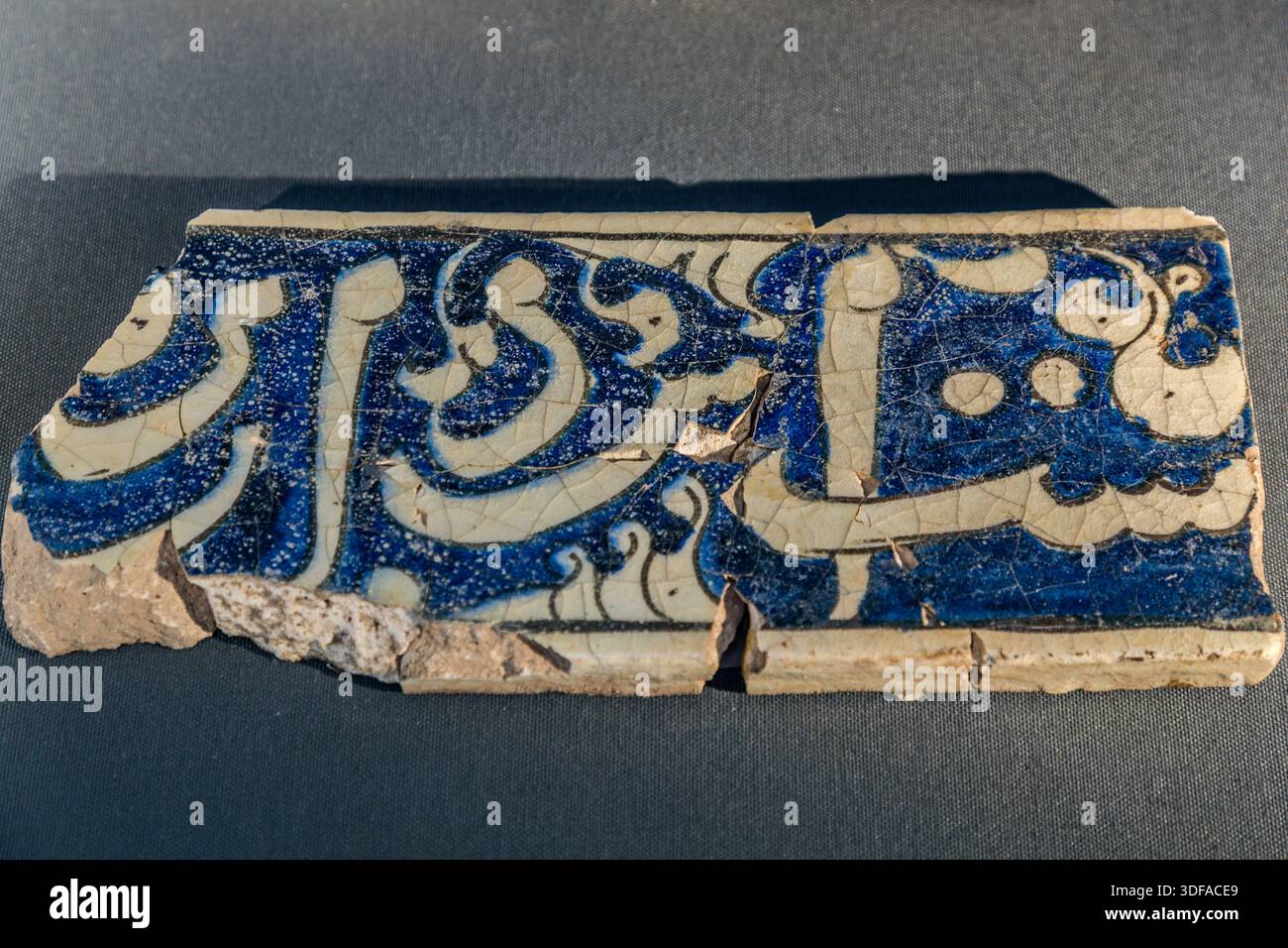 La Madrasa Karatay (Karatay Medresesi) a Konya, in Turchia, mostra un frammento di piastrella con smalto blu e bianco, calligrafia araba e una crepa diagonale al centro. Il visir selgiuchide Emir Celaleddin Karatay (m. 1254) fece costruire l’ex collegio islamico nel 1251 nel quartiere Ferhuniye. Dal 1954 l’edificio funge da museo delle piastrelle (Museo delle Opere di Piastrelle di Konya). Foto Stock