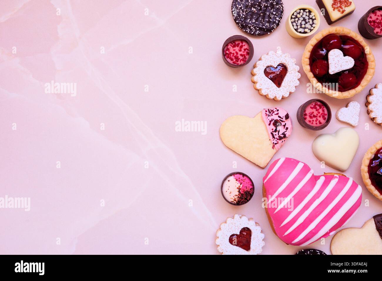 Il giorno di San Valentino, forno e dessert, con una varietà di biscotti, cioccolatini e dolci. Sopra la vista su uno sfondo in pietra rosa con copia Foto Stock