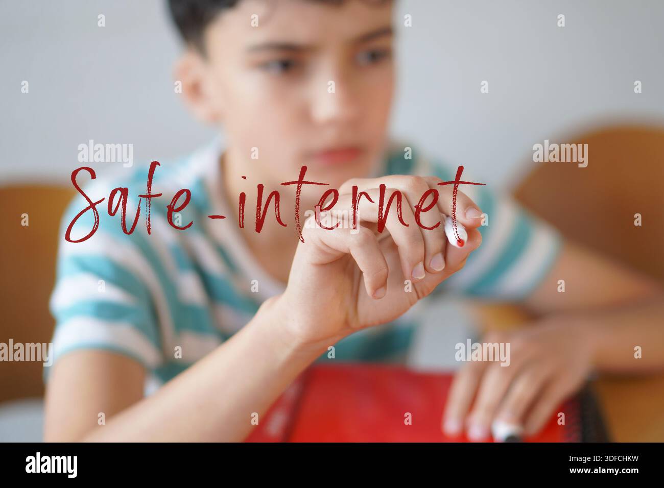 internet sicuro. bambini e uso delle tecnologie. Preadolescente che scrive il testo sullo schermo con un marcatore rosso Foto Stock
