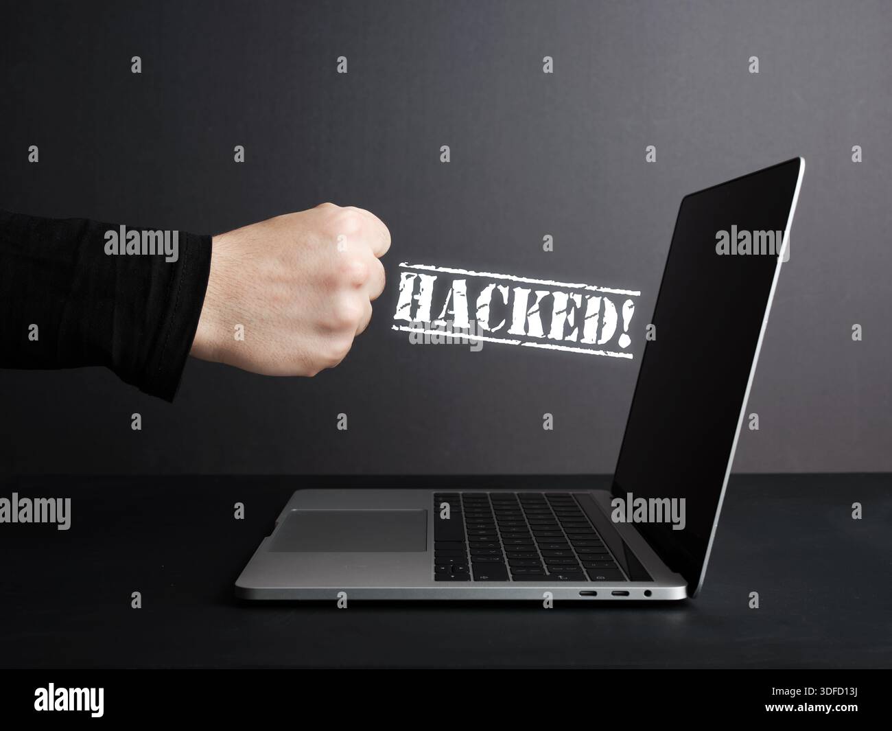 Un hacker che colpisce un laptop con messaggi hacker che appaiono, cyber crimine e concetto di violazione della sicurezza Foto Stock
