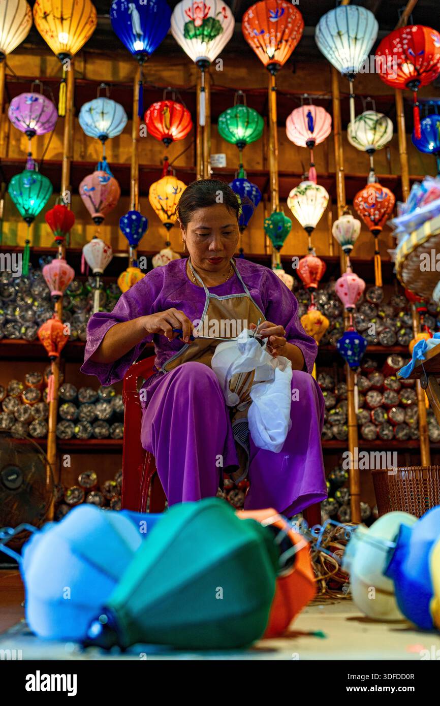 Donna che crea lanterne colorate, Vietnam Foto Stock