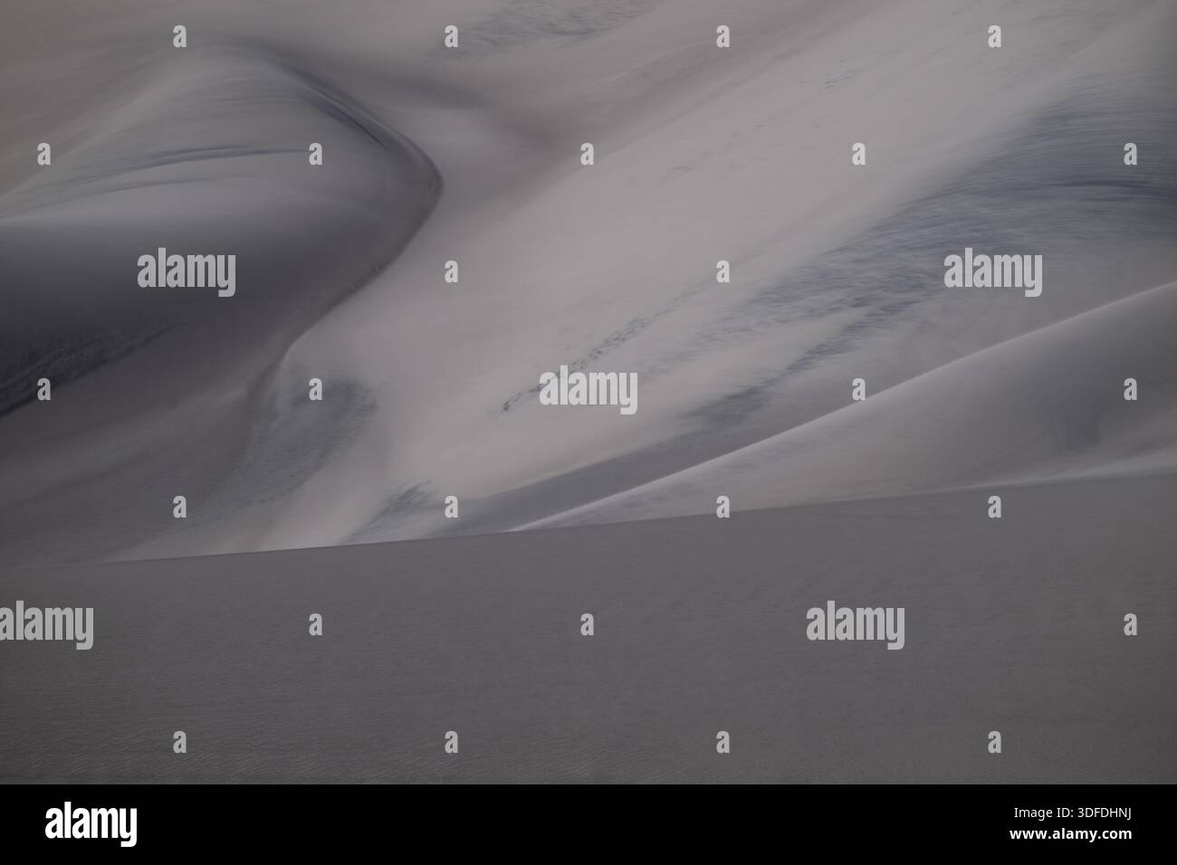 Vista ad alto angolo delle dune di sabbia in un paesaggio desertico, estetica monocromatica, che enfatizza le texture naturali, increspature soffiate dal vento e ombre curve. Foto Stock
