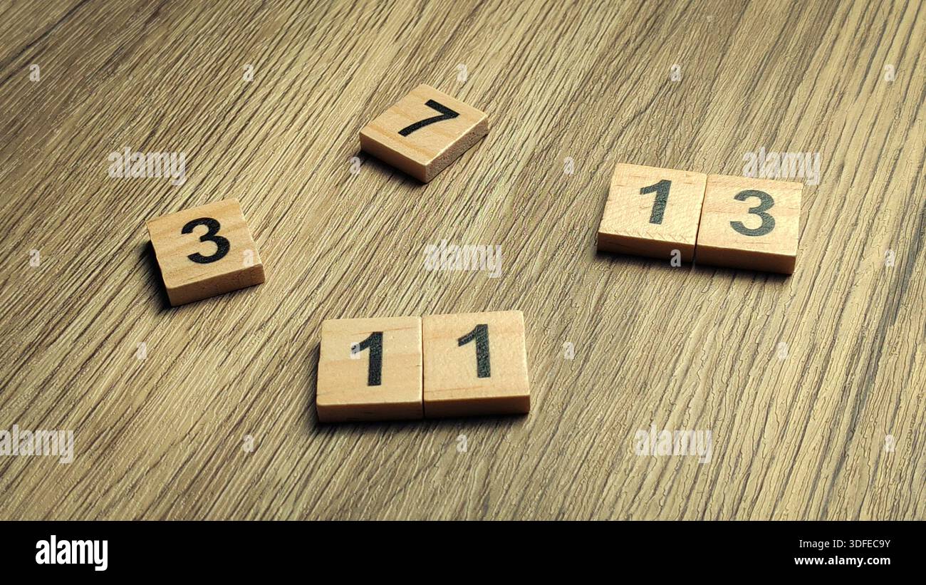 Collezione di mattonelle di legno a numero primo sparse su un tavolo di legno per il concetto di matematica e istruzione Foto Stock