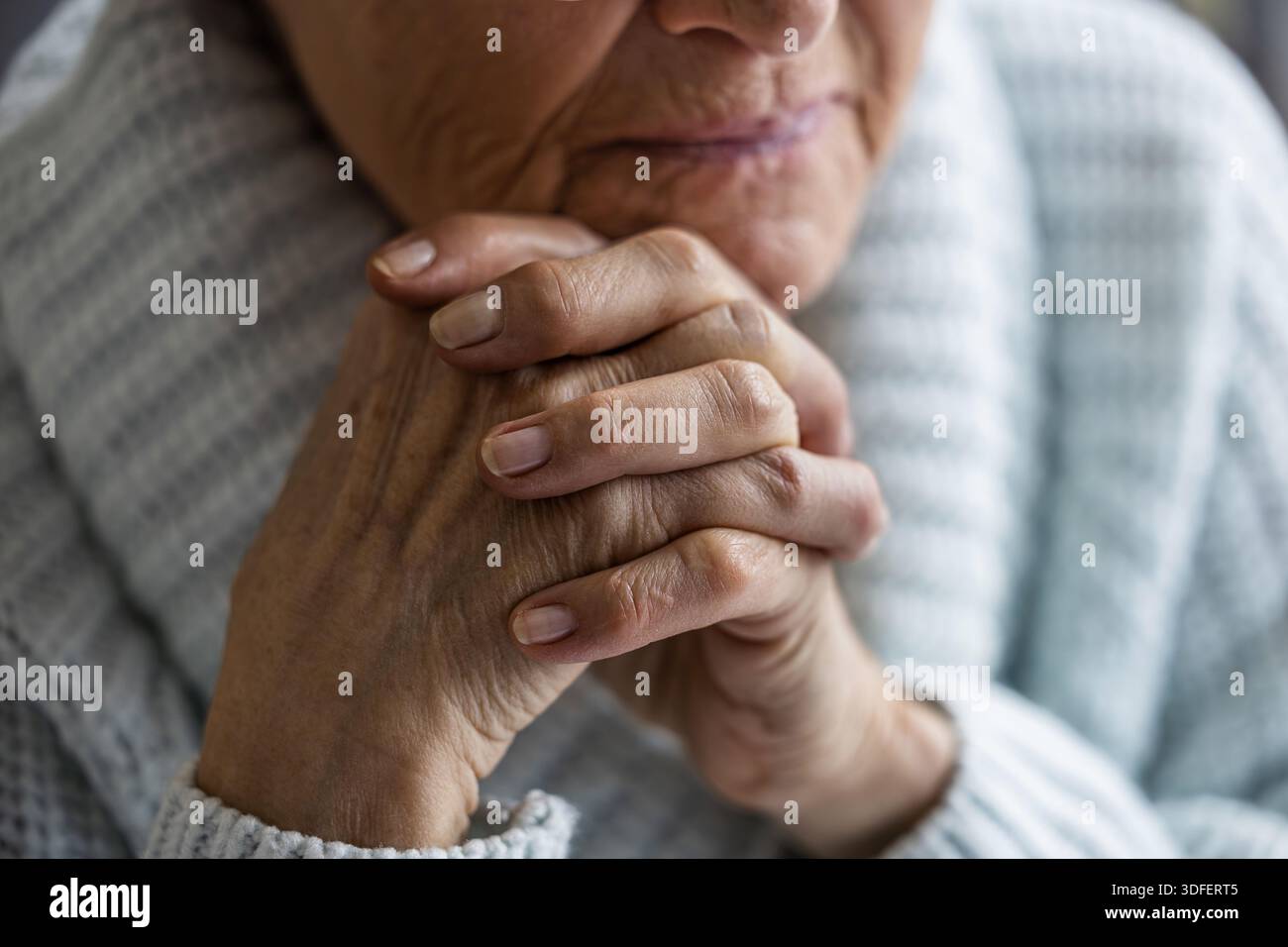 Donna anziana che riposa la testa sulle mani, primo piano Foto Stock