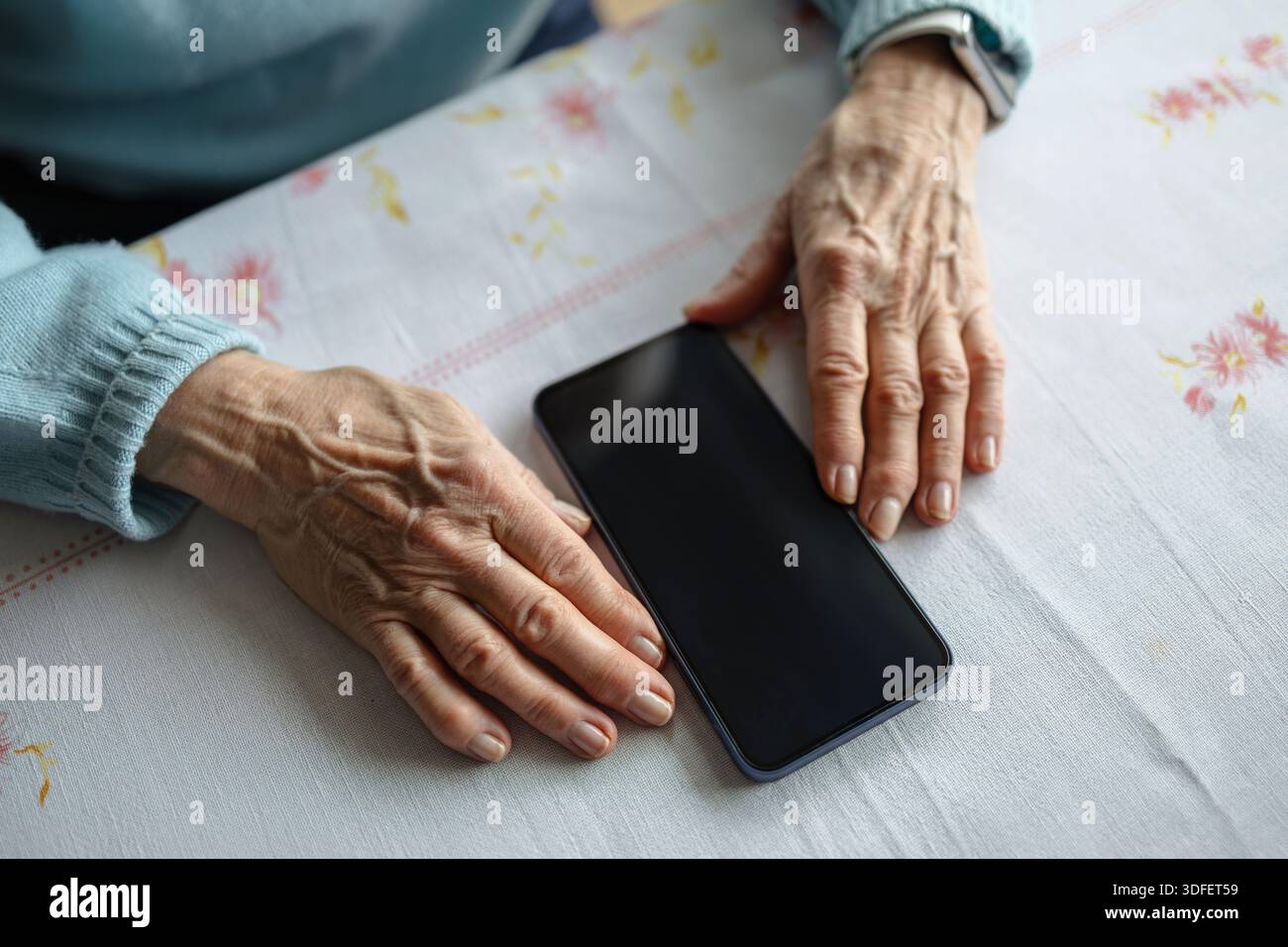 Donna anziana che usa lo smartphone a casa Foto Stock