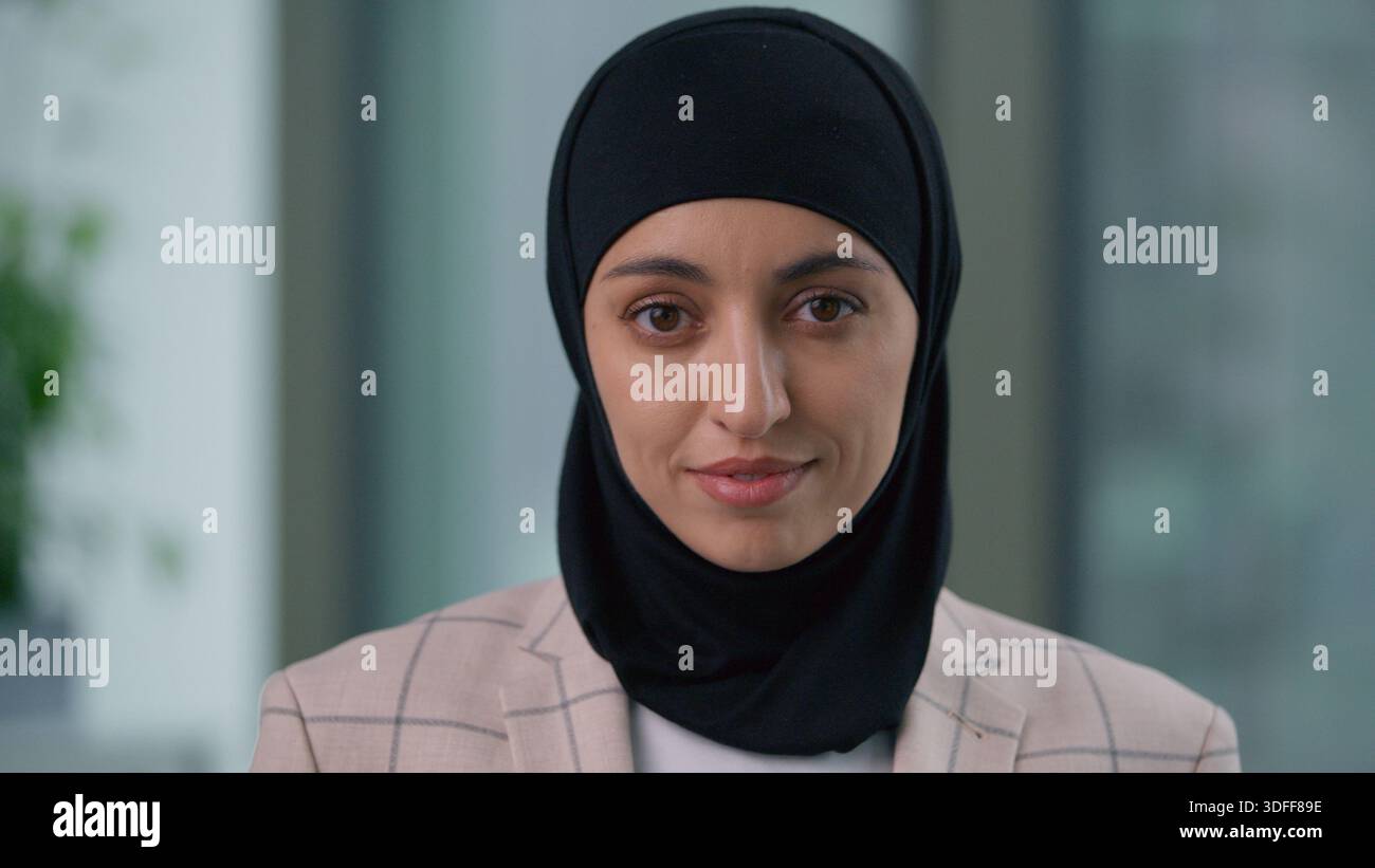 Ritratto in ufficio felice calma Araba etnica musulmana donna d'affari indiana islamica che guarda la macchina fotografica che indossa hijab professionale femminile Foto Stock