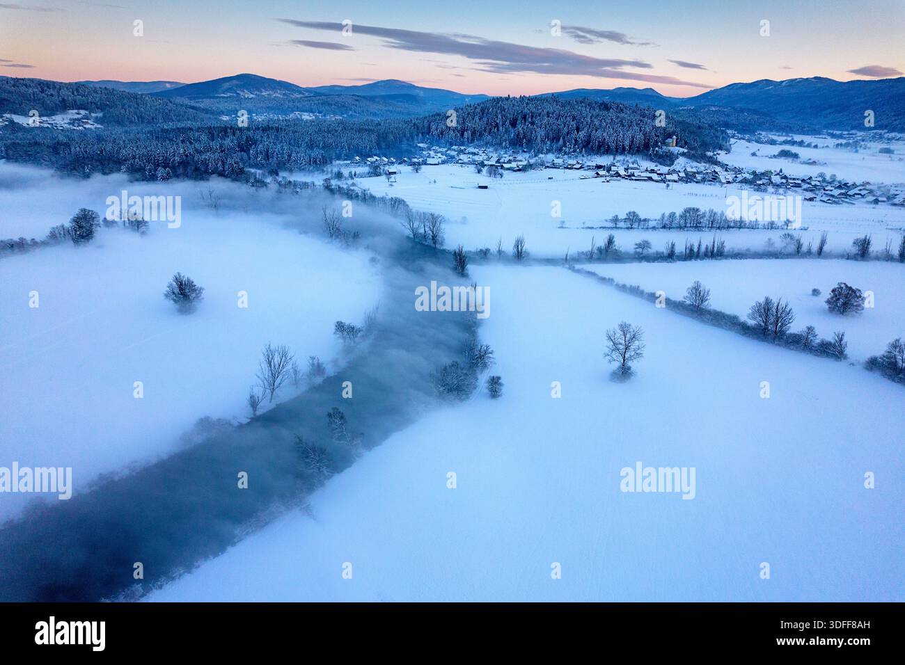 Spettacolare nebbia che si innalza da un freddo fiume Krka in una fredda mattina invernale nevosa nella regione di Dolenjska in Slovenia, paesaggio ghiacciato invernale, Novo mesto Foto Stock