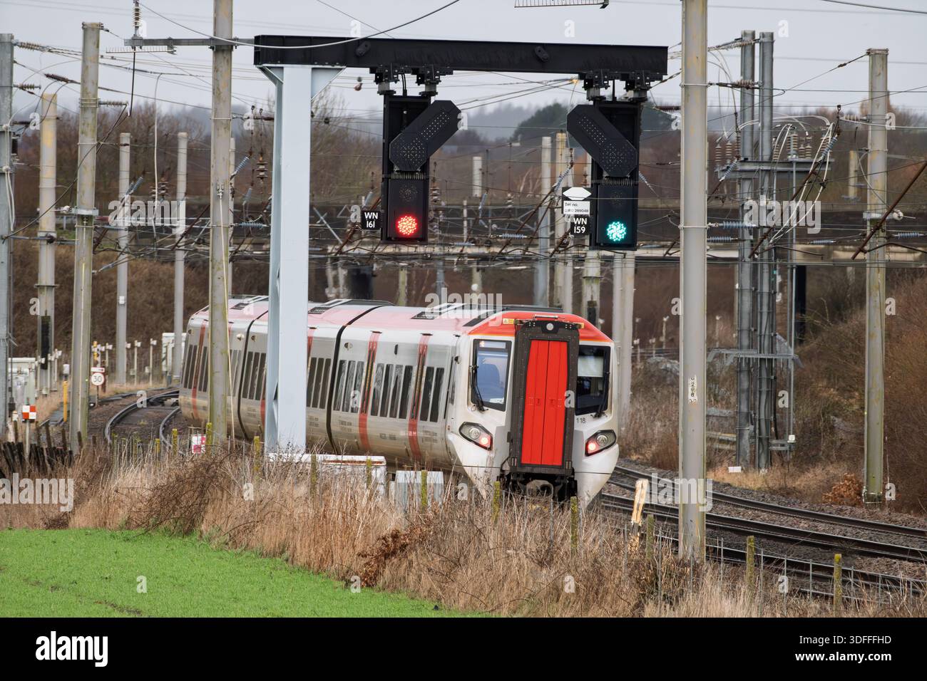 Fornitura di energia elettrica per la linea ferroviaria principale della costa occidentale britannica, come prova allo svincolo di Winwick, come treni di classe 197 per la DMU del Galles diretti a nord. Foto Stock
