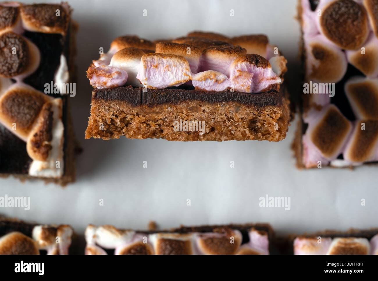 Un macro shot che mostra i ricchi strati di una barra S'mores: Una croccante base di cracker graham, uno spesso strato di cioccolato fondente e un morbido toaste dorato Foto Stock