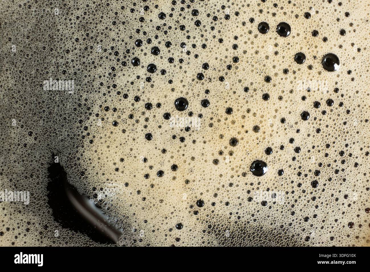 Consistenza macro della schiuma di caffè dorata con molte piccole bolle Foto Stock