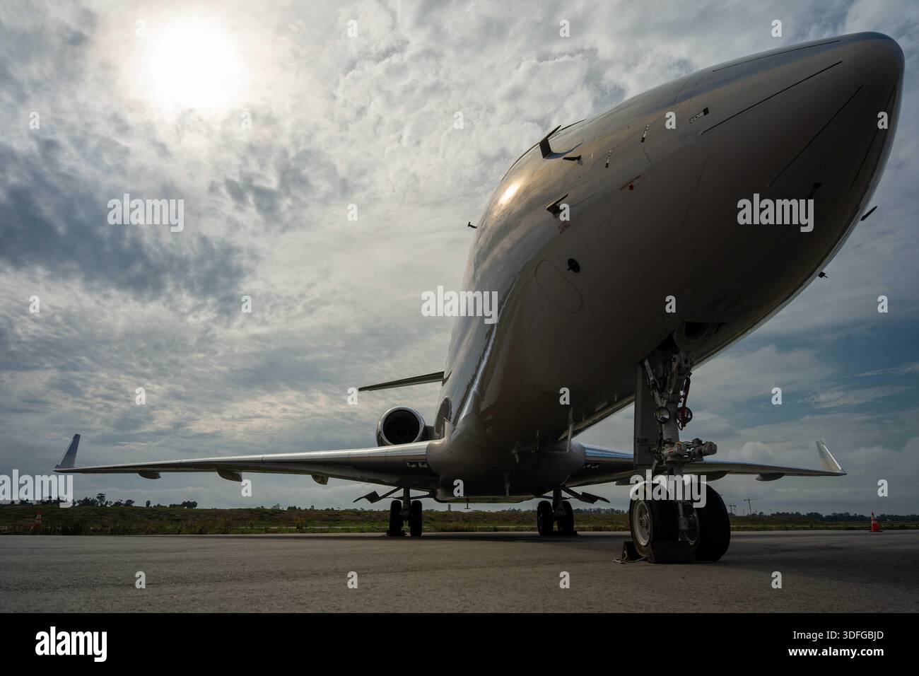 Jet privato parcheggiato su un asfalto con un bel cielo sullo sfondo. Foto Stock