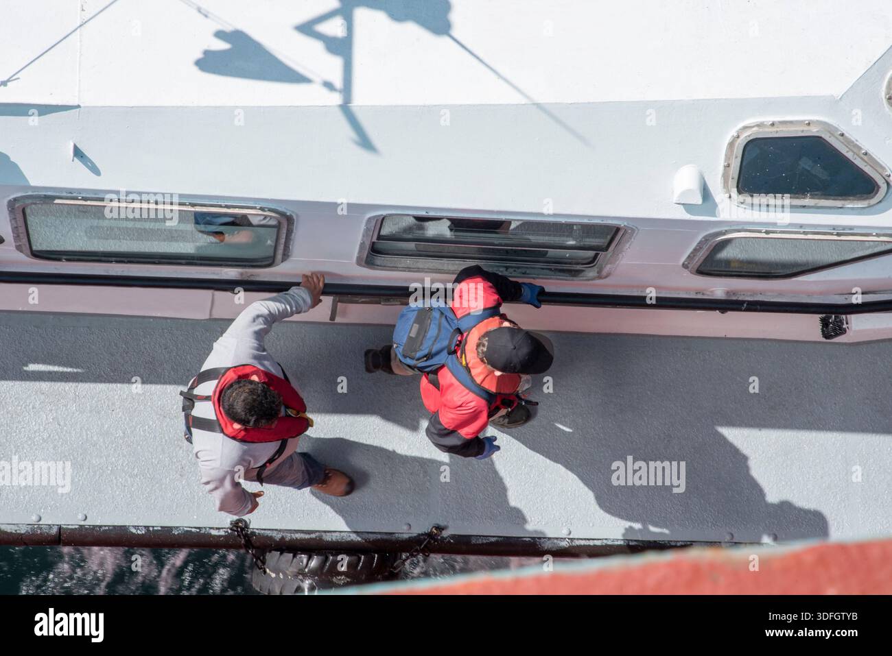 Vista dall'alto verso il basso del ponte del pilota con pilota marittimo e equipaggio durante le operazioni di trasferimento del pilota. Foto Stock