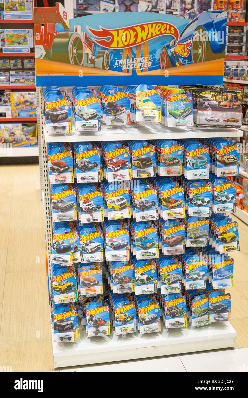 Macchinine giocattolo in metallo pressofuso Hot Wheels esposte in un grande stand all'interno di un negozio di giocattoli, che mostra il famoso marchio di auto in miniatura e i modelli da collezione. Foto Stock