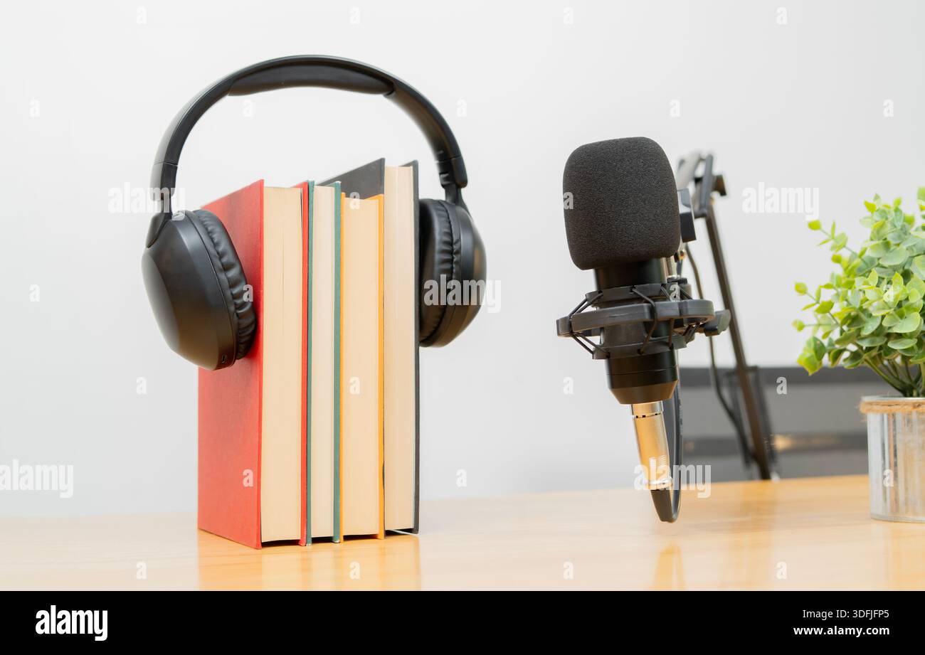 Un supporto per microfono professionale con libro e cuffie per la registrazione o la trasmissione. Concetto di podcast. Foto Stock