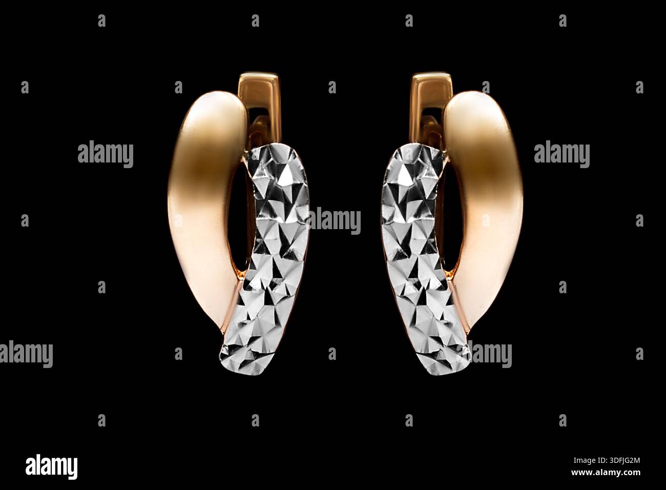Eleganti orecchini in oro giallo e bianco isolati sul nero Foto Stock