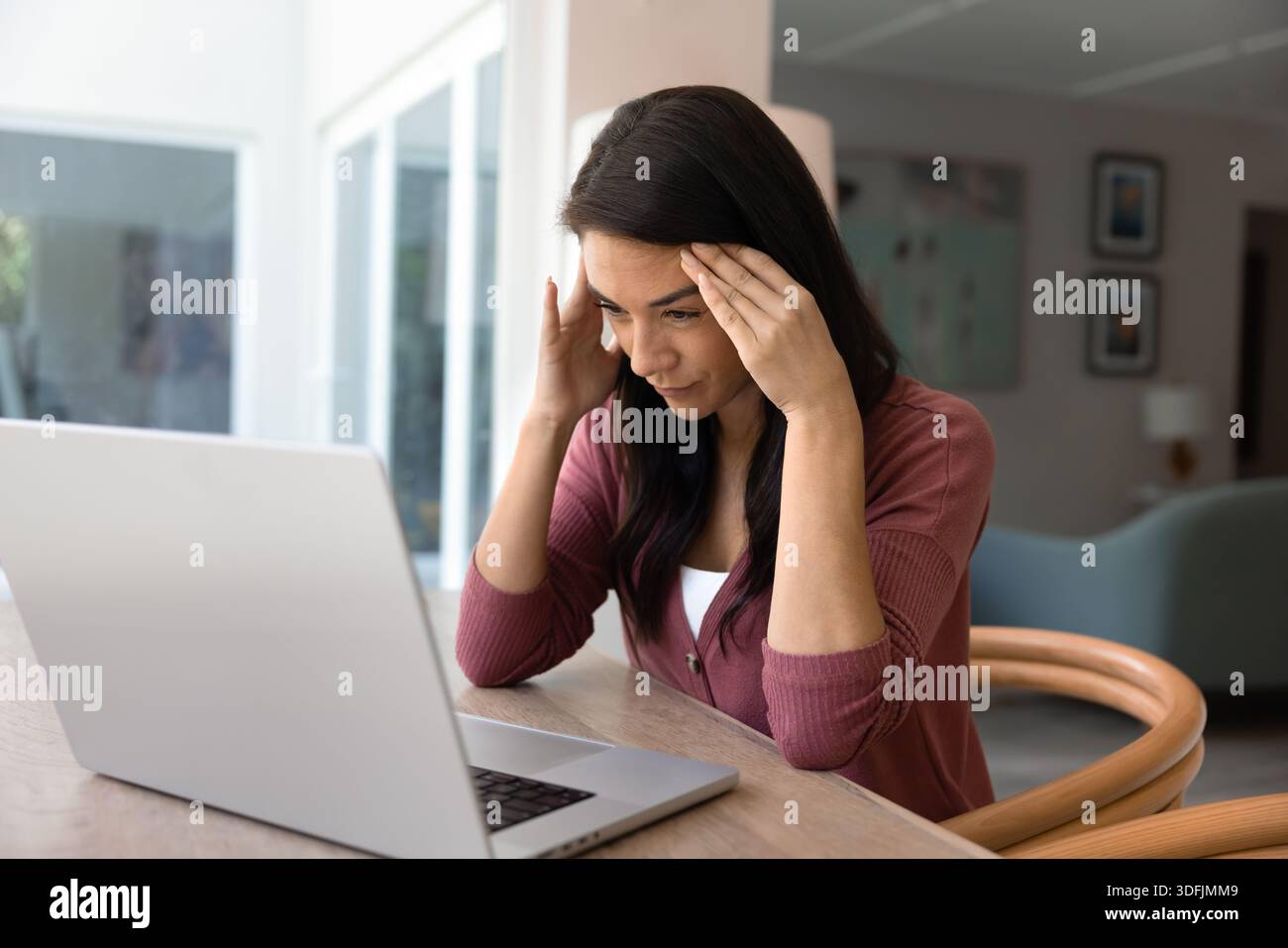 Donna che tiene la testa sotto la frustrazione dovuta al malware del notebook Foto Stock