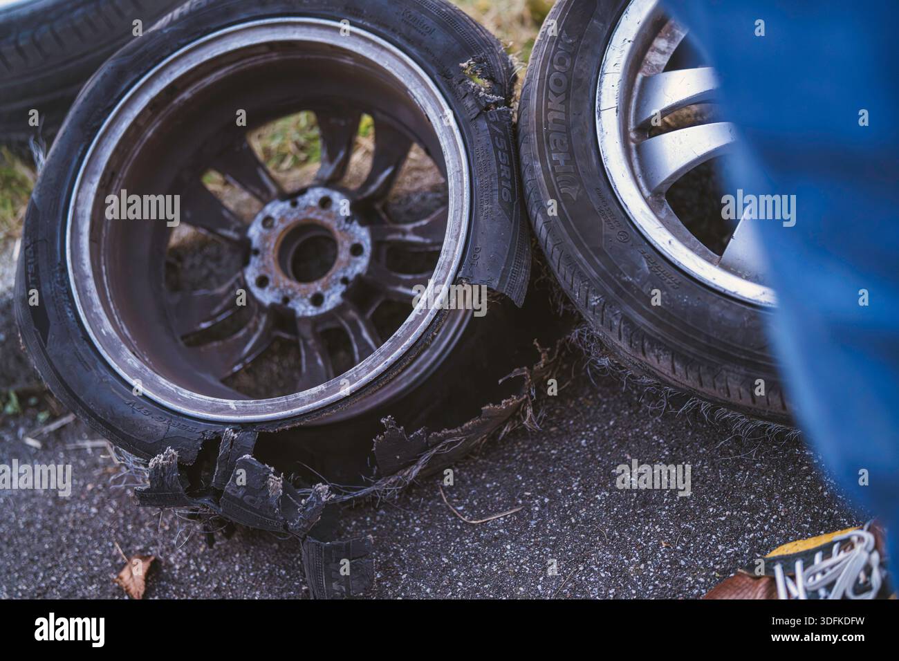 Imola, italia 01 gennaio 2026: Pneumatici per auto in panne con fianchi stracciati e corde esposte adagiate su asfalto, dettaglio ravvicinato di negligenza e gravi danni Foto Stock