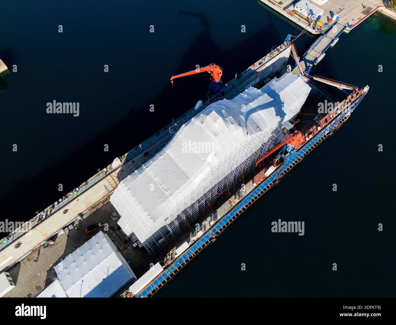 Vista aerea di uno yacht di lusso, riparazione, assistenza e manutenzione in un molo galleggiante di un porticciolo. Foto Stock
