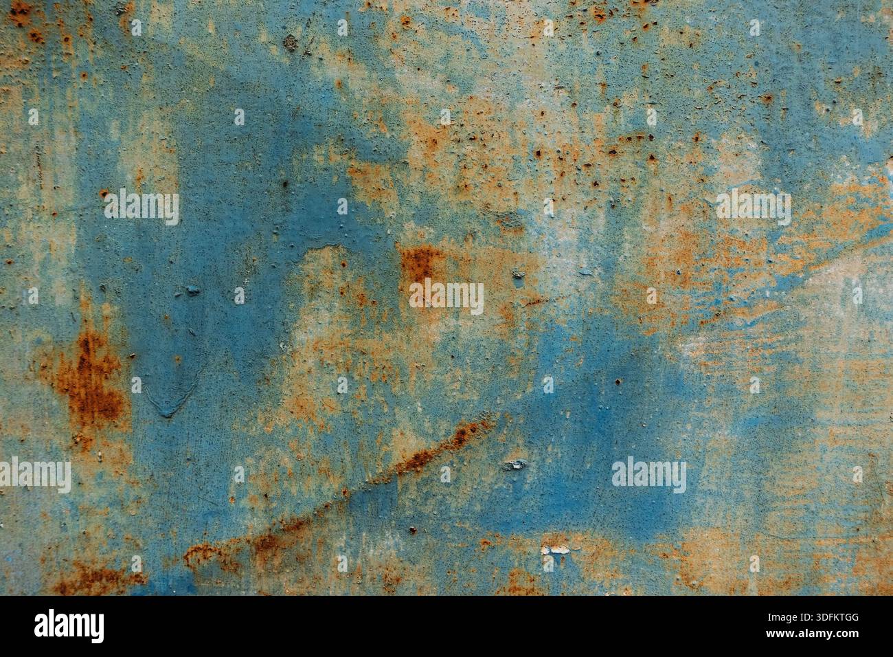 Superficie in metallo blu arrugginito con vernice spelante e motivi di corrosione, che mostrano degrado industriale e consistenza intemprata Foto Stock