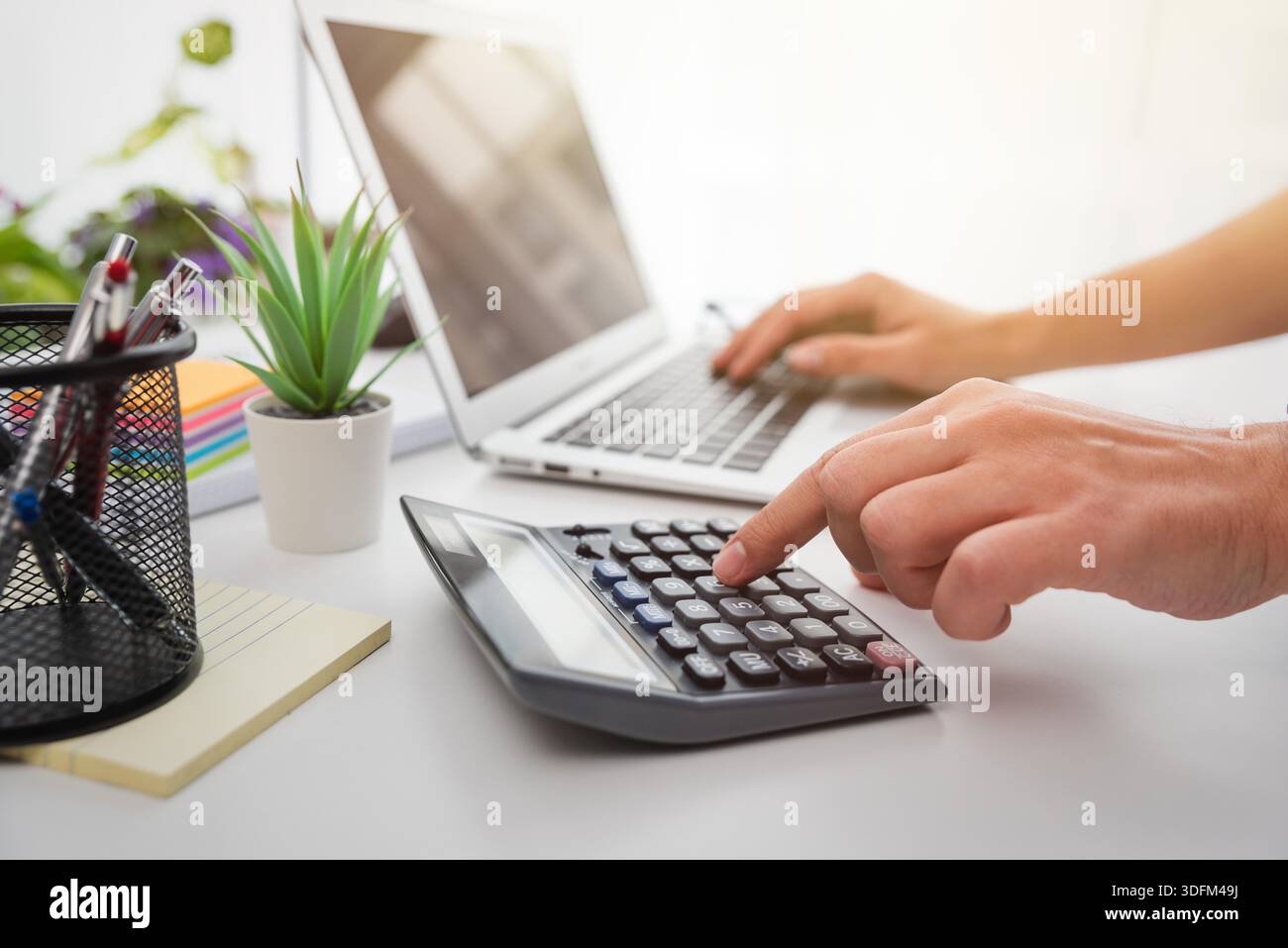 Primo piano dell'uomo che pianifica il budget domestico e utilizza la calcolatrice. Foto Stock
