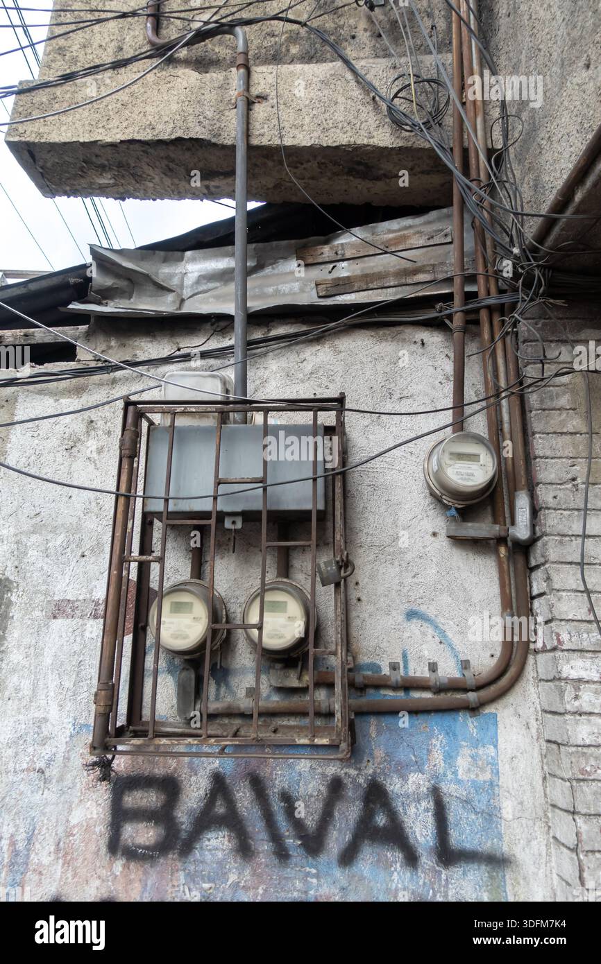 contatori elettrici multipli racchiusi in una gabbia di sicurezza in metallo arrugginito. Utility Infrastructure, Cebu City, Filippine Foto Stock