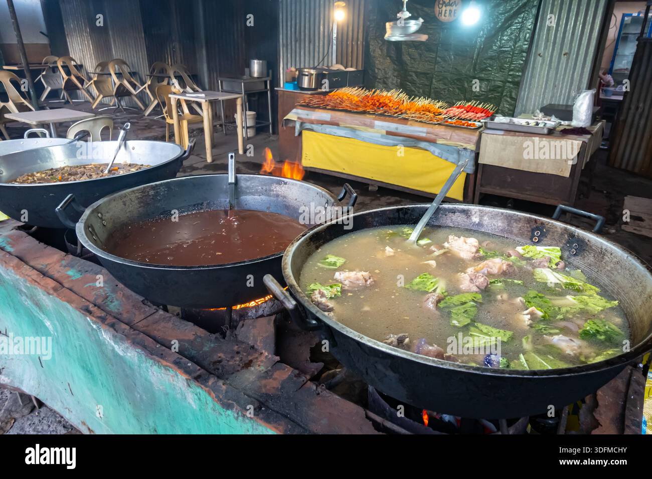Vivace stand di Street food, città di Cebu, Filippine, specializzato in piatti a cottura lenta e di grandi dimensioni. Stufato, brodo, zuppa Foto Stock