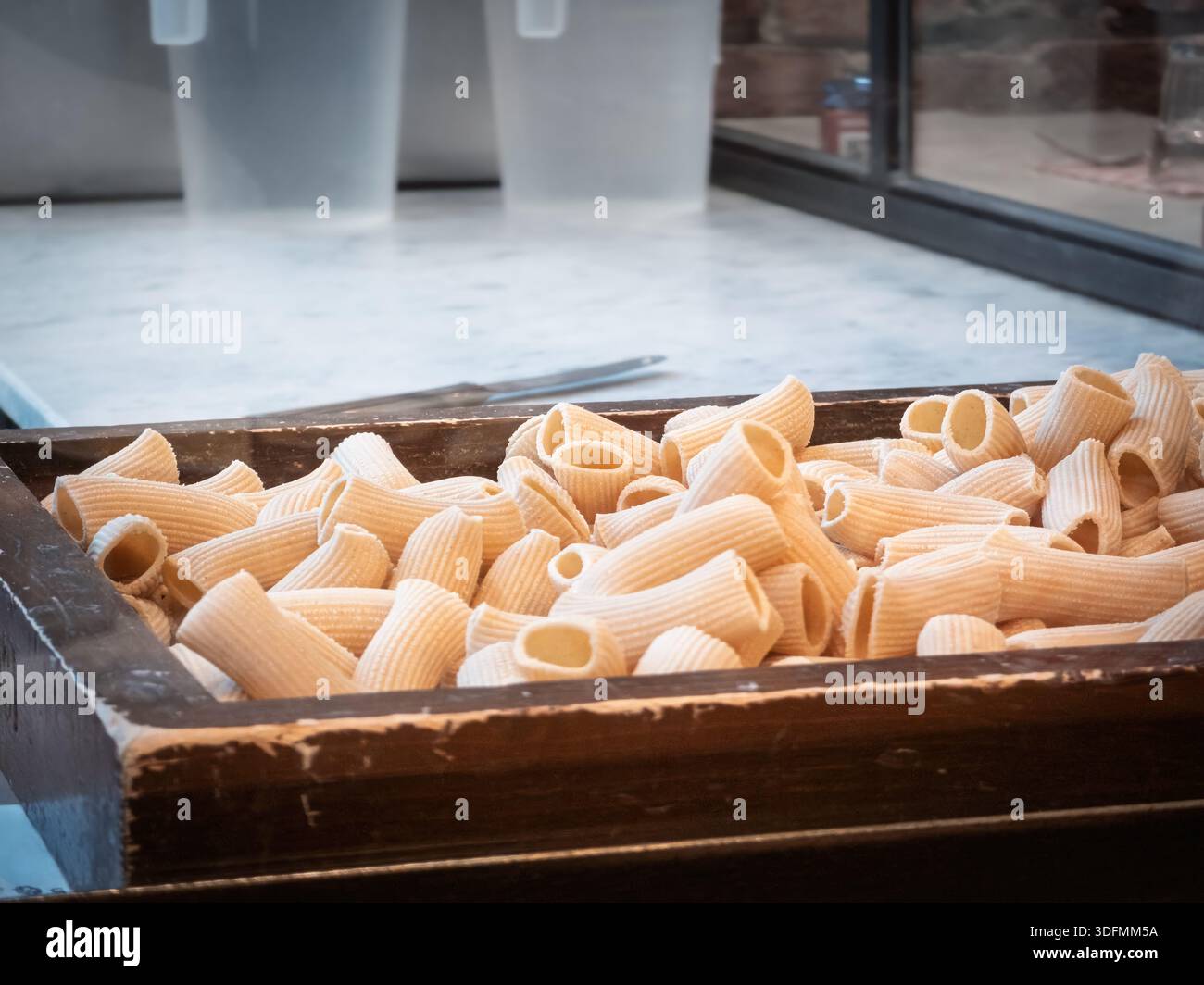 Rigatoni italiani freschi fatti in casa che riposano in un vassoio di legno Foto Stock