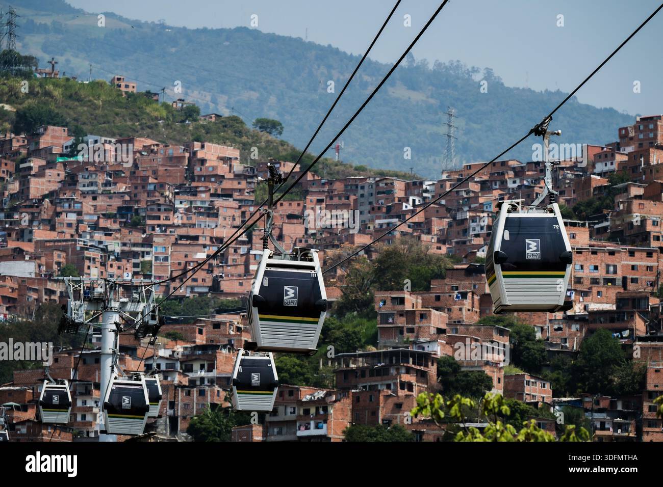 La vista della funivia scivola su una vasta favela collinare, un arazzo di case in mattoni che si arrampicano verso le lussureggianti montagne verdi, Medellin, Colombia. Foto Stock