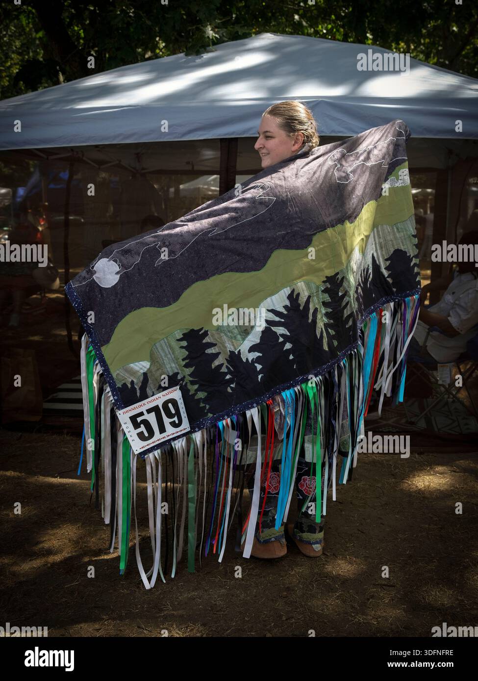 Ritratto completo di un membro della tribù dei nativi americani Mohegan che indossa uno scialle frangiato fatto a mano. Al 2022 Shinnecock Powwow. Foto Stock