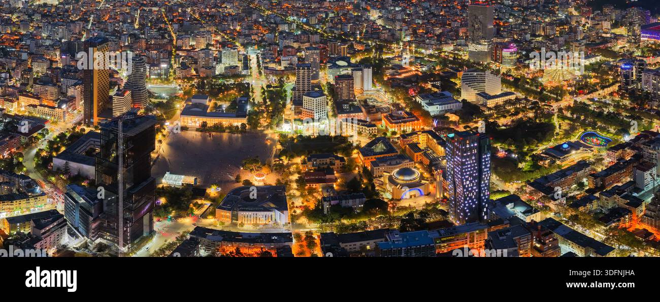 Panorama aereo notturno di Tirana che mostra Piazza Skanderbeg, le luci della città e lo skyline illuminato della capitale albanese. Foto Stock