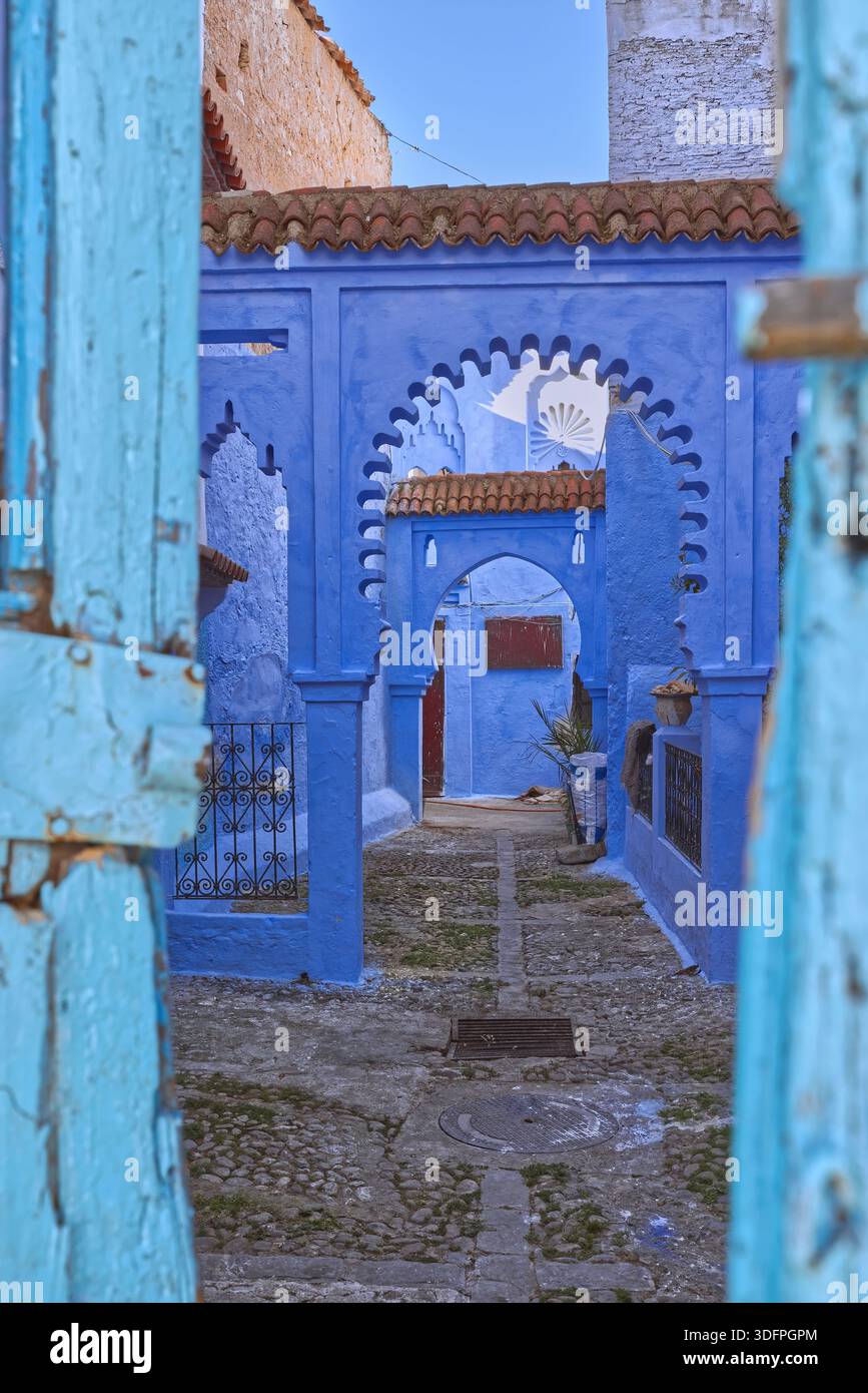 052 vicolo cieco semi-privato con due archi sul lato sud-ovest di Plaza El Hauta-Hawta Square, nascosto dietro la sua porta di legno malandato. Chefchaouen-Marocco. Foto Stock