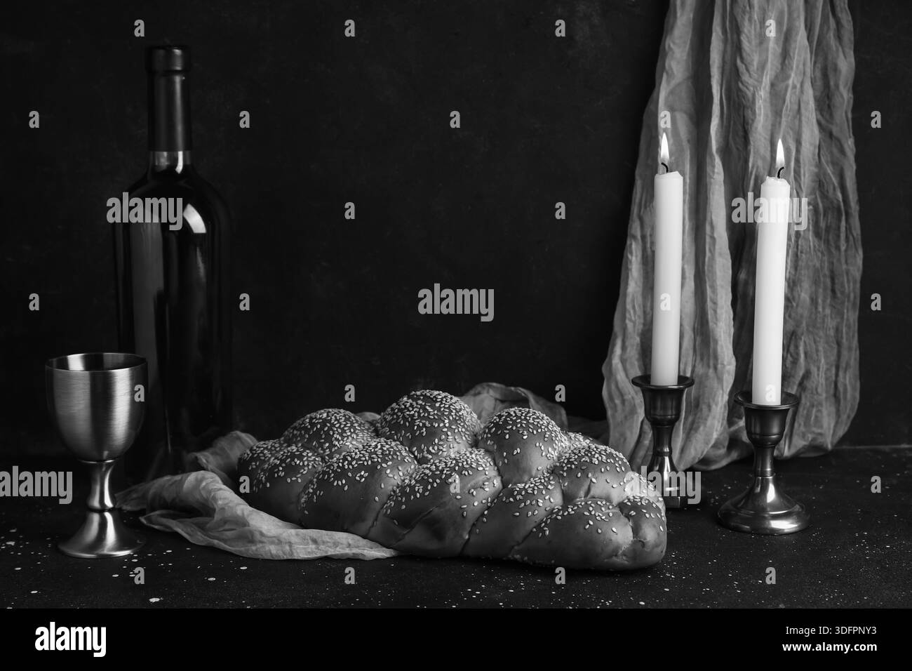 Pane tradizionale con vino e candele accese sulla tavola scura. Shabbat Shalom Foto Stock