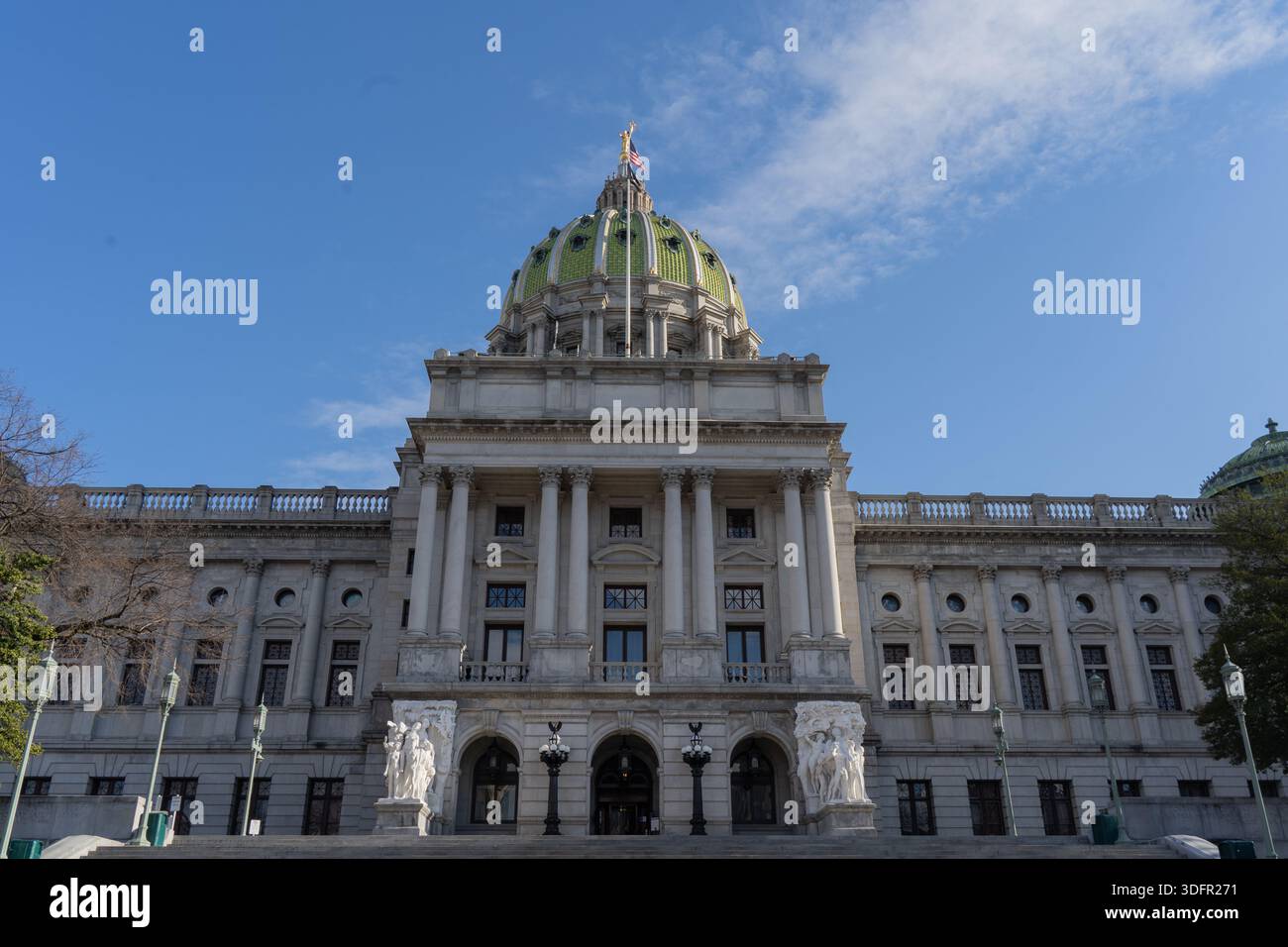 Harrisburg, Pennsylvania – 11 gennaio 2026: Le bandiere sorvolano il Campidoglio della Pennsylvania con la sua distintiva cupola verde. Foto Stock