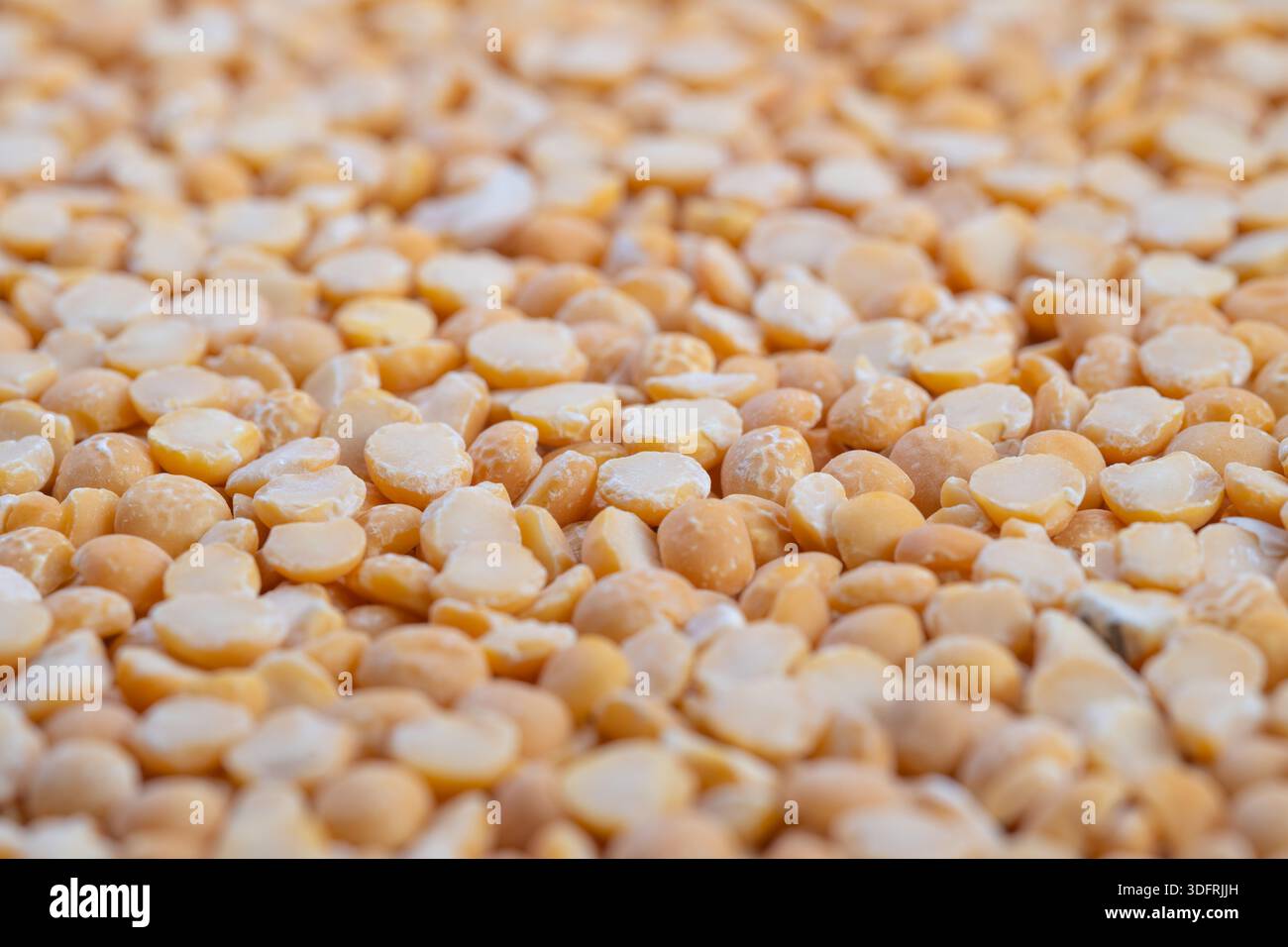 Messa a fuoco superficiale su piselli divisi, morbidi riflessi bokeh, forme circolari ripetute, accoglienti tonalità dorate, motivo culinario astratto, fotografia di scorta f Foto Stock