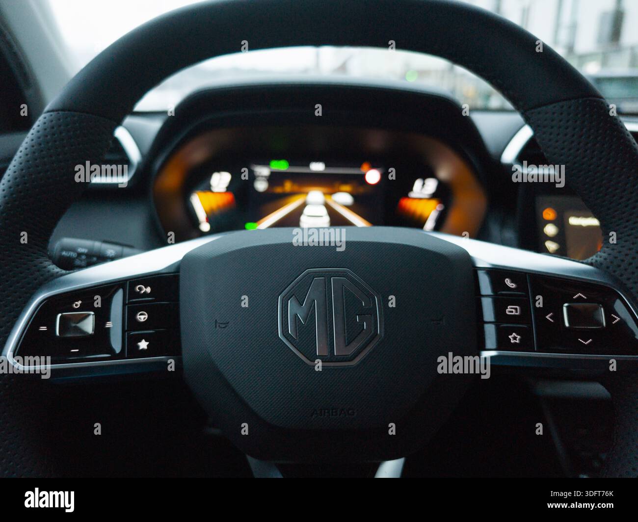 Primo piano del volante di un'auto MG e del cruscotto digitale con moderni comandi interni. Foto Stock