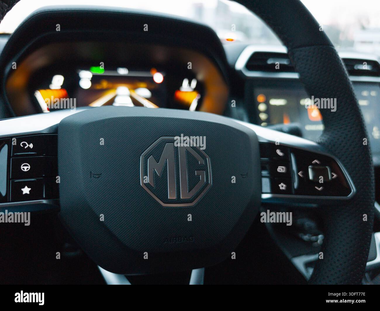 Primo piano del volante di un'auto MG e del cruscotto digitale con moderni comandi interni. Foto Stock