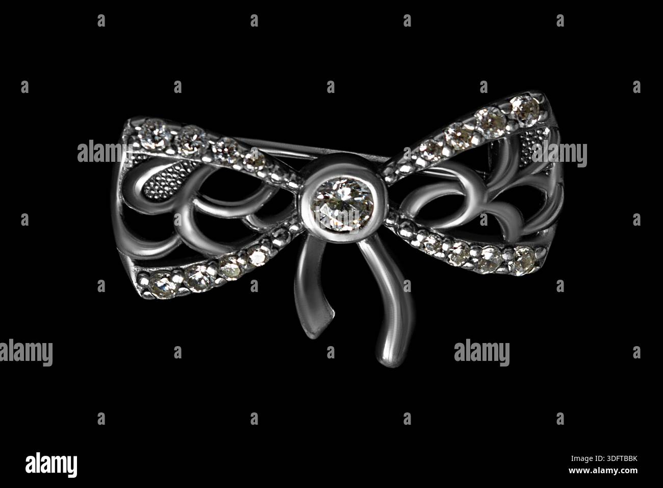 Spilla a forma di fiocco in oro bianco con cristalli isolati sul nero Foto Stock