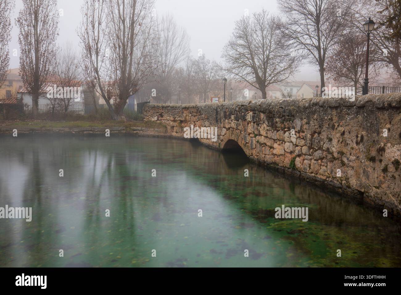 Fonte del fiume Cifuentes nella città omonima di Guadalajara, Spagna, in una bella giornata nebbiosa Foto Stock