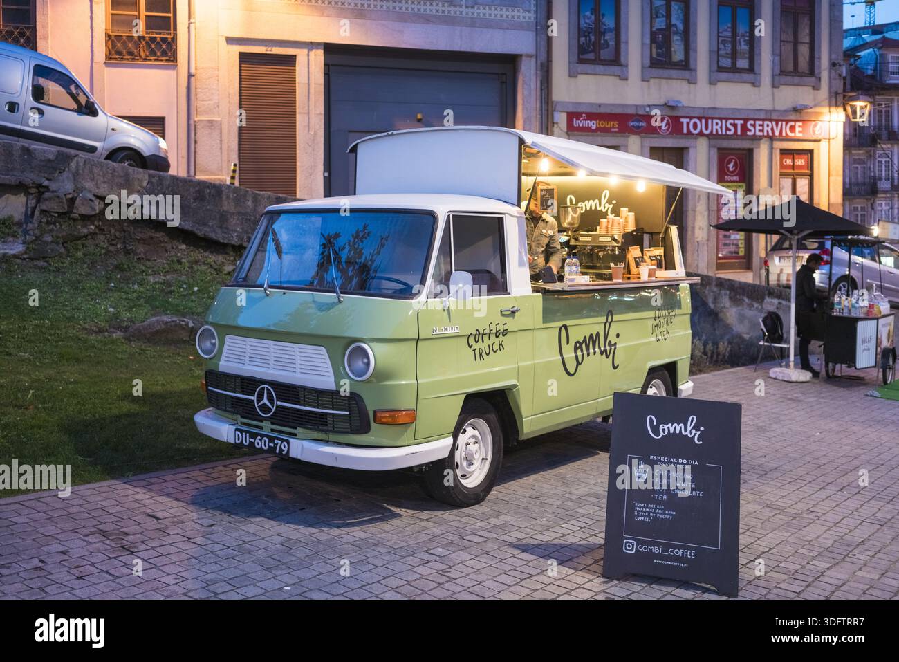 Porto, Portogallo - 26 novembre 2017: La vista di un camion del caffè Combi illuminato si distingue per i toni tenui dell'edificio dei servizi turistici. Foto Stock