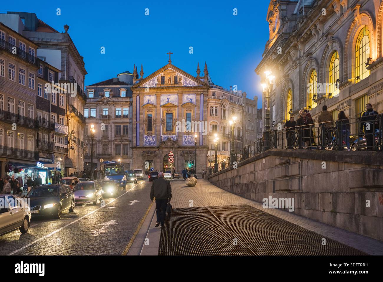 Porto, Portogallo - 26 novembre 2017: Veduta della facciata illuminata della chiesa di Igreja dos Congregados che getta un bagliore dorato sulla strada mentre il crepuscolo si stabilizza Foto Stock