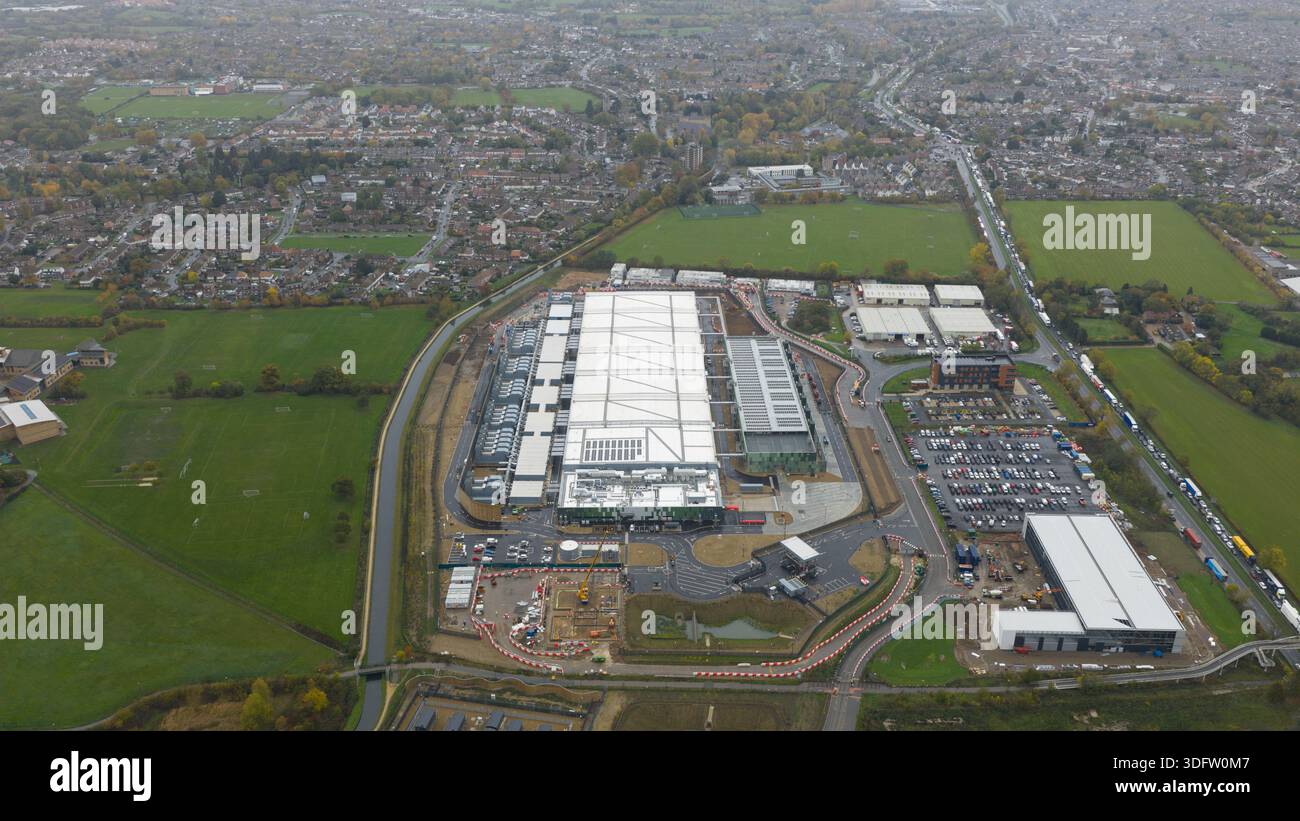 Veduta aerea del vasto complesso di datacenter, una moderna griglia contro il mosaico di campi verdi e la città lontana, Waltham Cross, Regno Unito. Foto Stock
