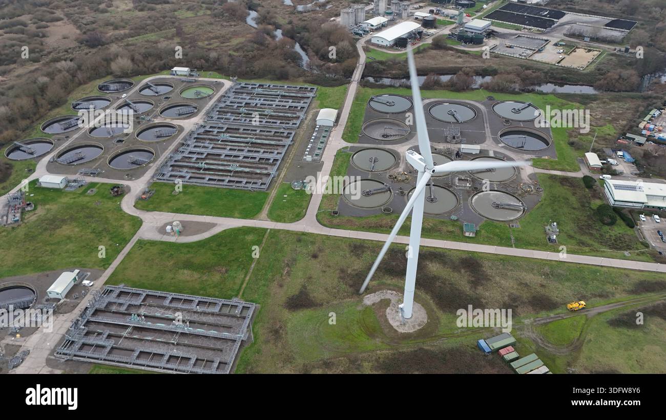 Veduta aerea di un paesaggio aspro dove una sola turbina eolica si erge in mezzo all'impianto di trattamento delle acque reflue vicino a West Service Road, Derby, Inghilterra, U Foto Stock