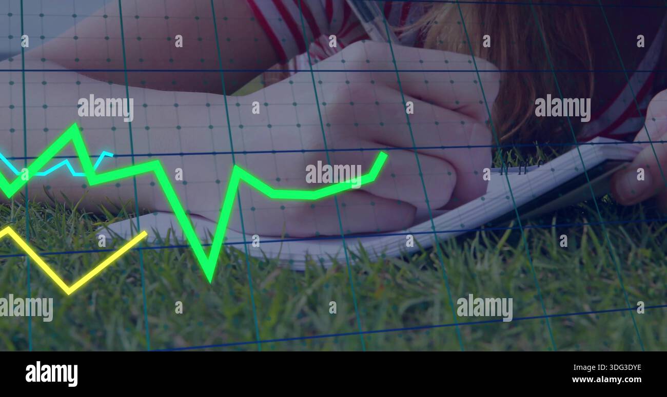 Donna che scrive camicia a righe distesa sull'erba, con penna su quaderno a spirale, grafici a linee al neon e griglia Foto Stock