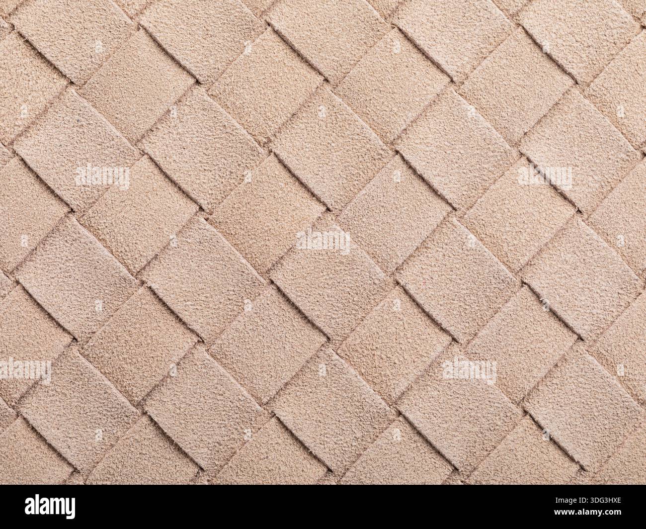 La texture beige della pelle scamosciata intrecciata, che forma una forma quadrata astratta, una fotografia autentica, non generata dall'intelligenza artificiale Foto Stock