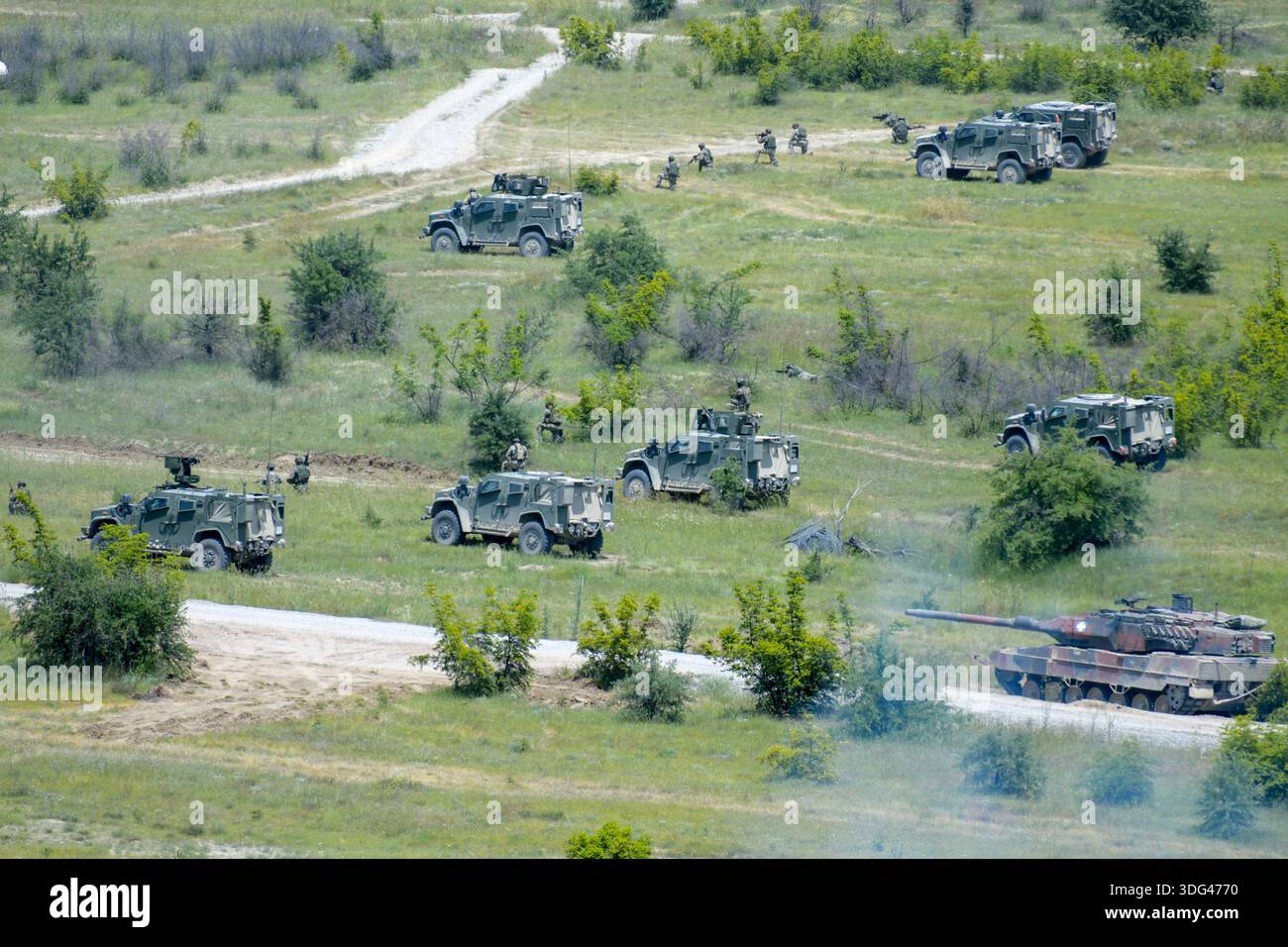 I veicoli corazzati e le unità di fanteria manovrano durante un'esercitazione militare in terreno aperto Foto Stock