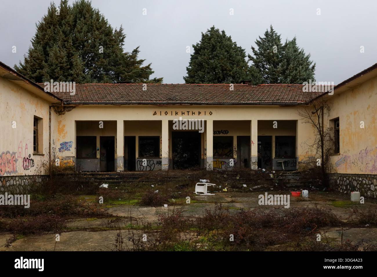 Kastoria, Grecia - 10 gennaio 2026. Ex struttura amministrativa militare (“Διοικητήριο”) è abbandonata e sopraffatta dalla natura e dal vandalismo. Foto Stock