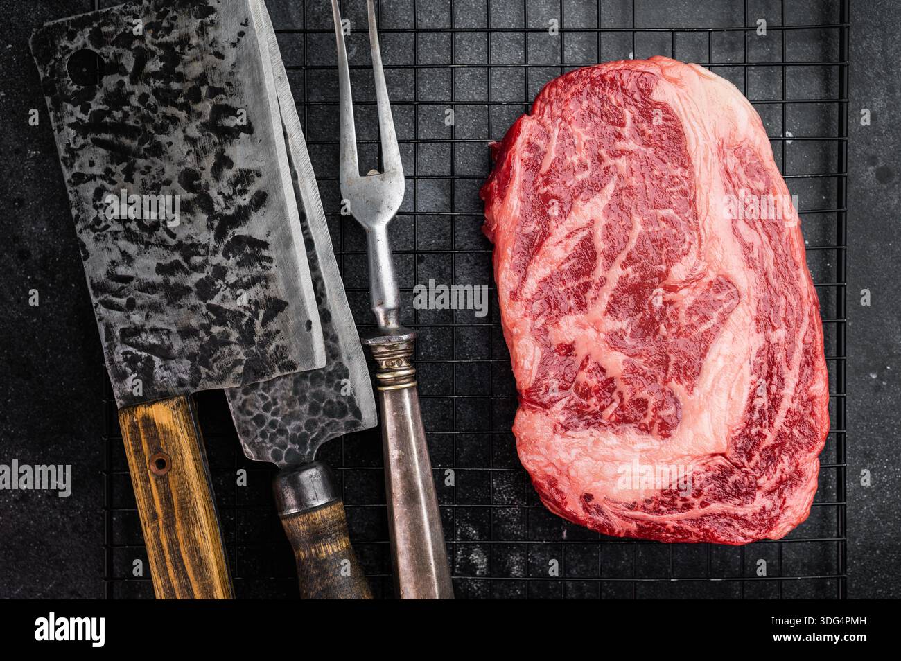 Bistecca cruda di riso nota anche come entrecote scotch o delmonico. Filetto di costolette di manzo marmorizzate tagliate su sfondo nero Foto Stock