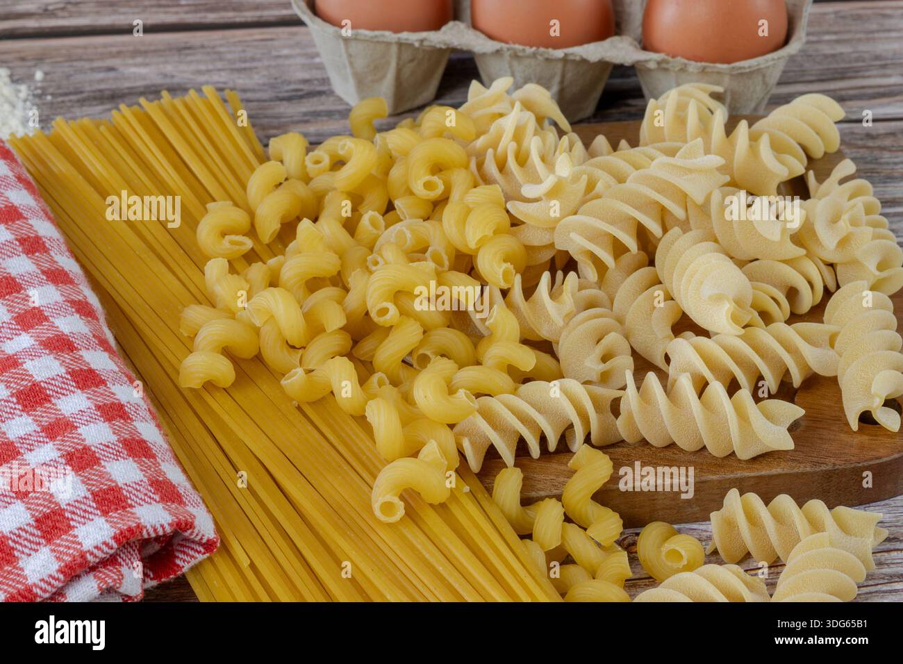 Pasta cruda su tavola di legno Foto Stock